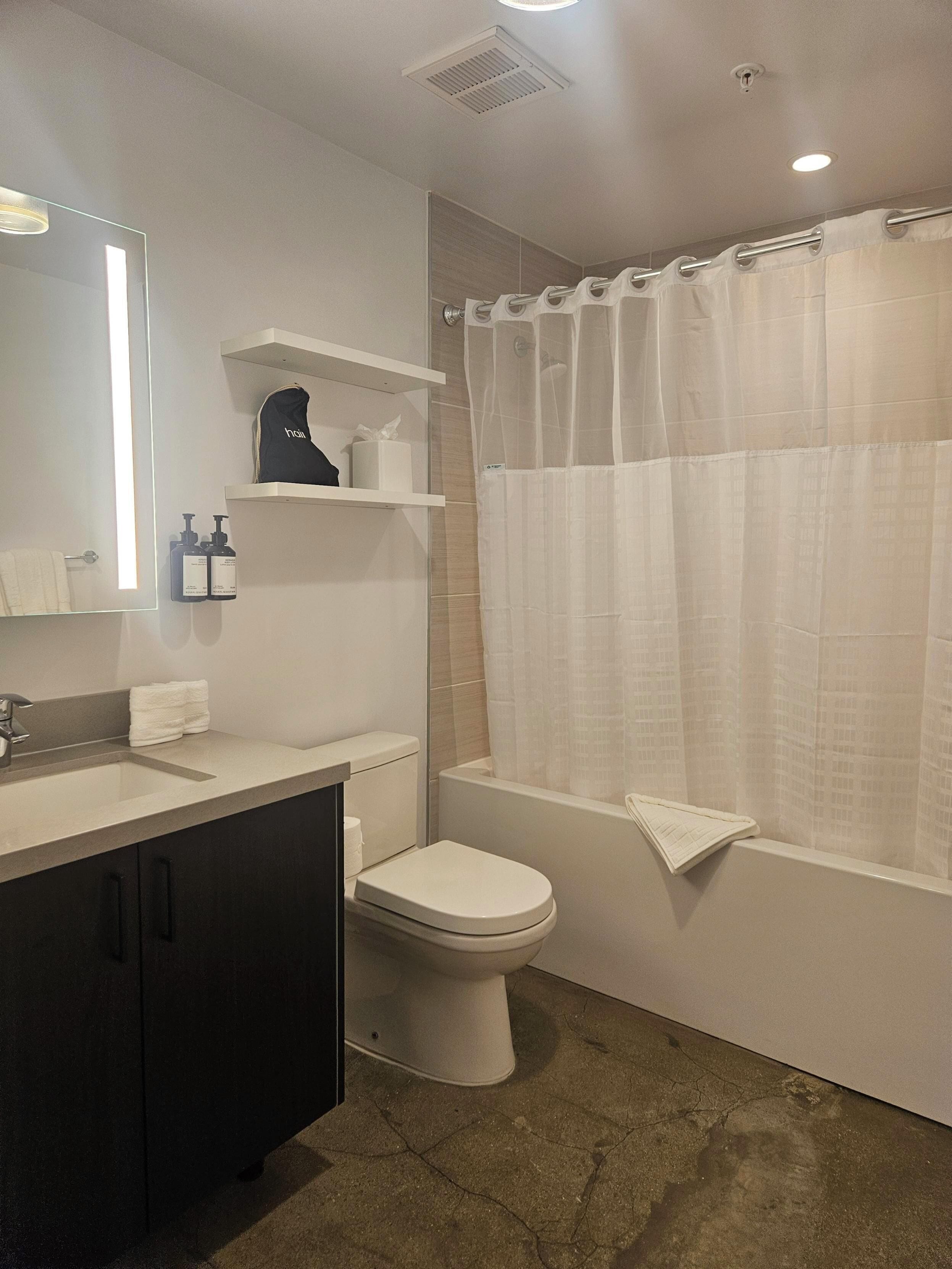 Un baño moderno con inodoro, lavamanos y zona de ducha.