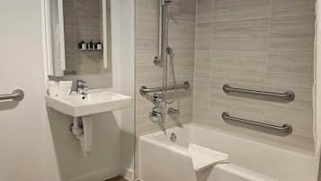 A bathroom with a shower, a sink, and a mirror.