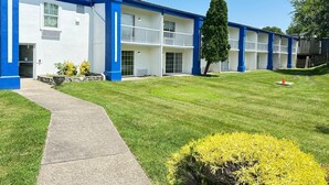A multi-story motel with a blue and white exterior, a paved walkway, and a well-maintained lawn. - Baymont By Wyndham Lexington (Lexington)