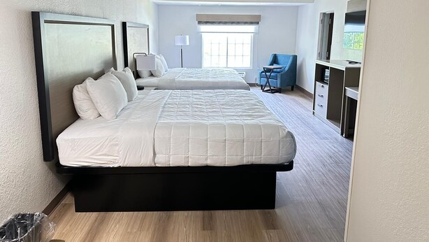 A hotel room with two beds, a desk, a chair, a TV, and a window. - Baymont By Wyndham Lexington (Lexington)