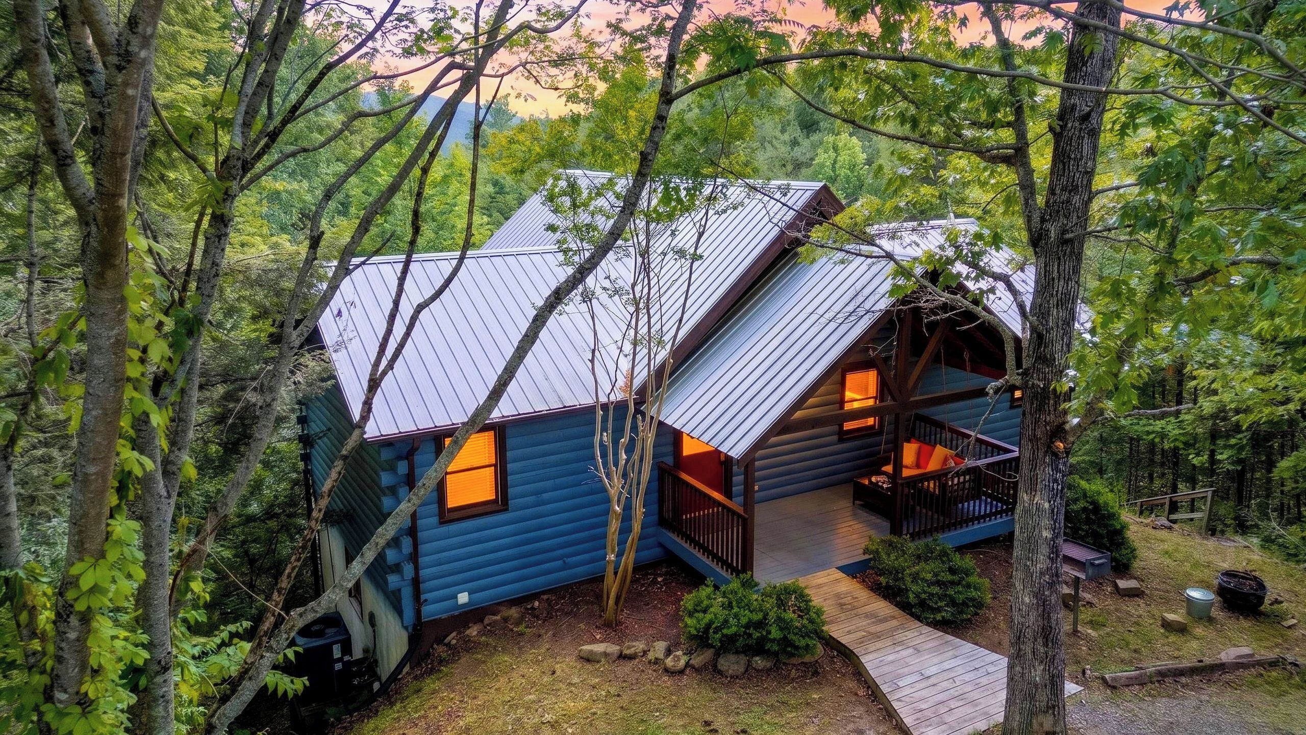 A cabin with a sloped roof, a porch, and a small deck.