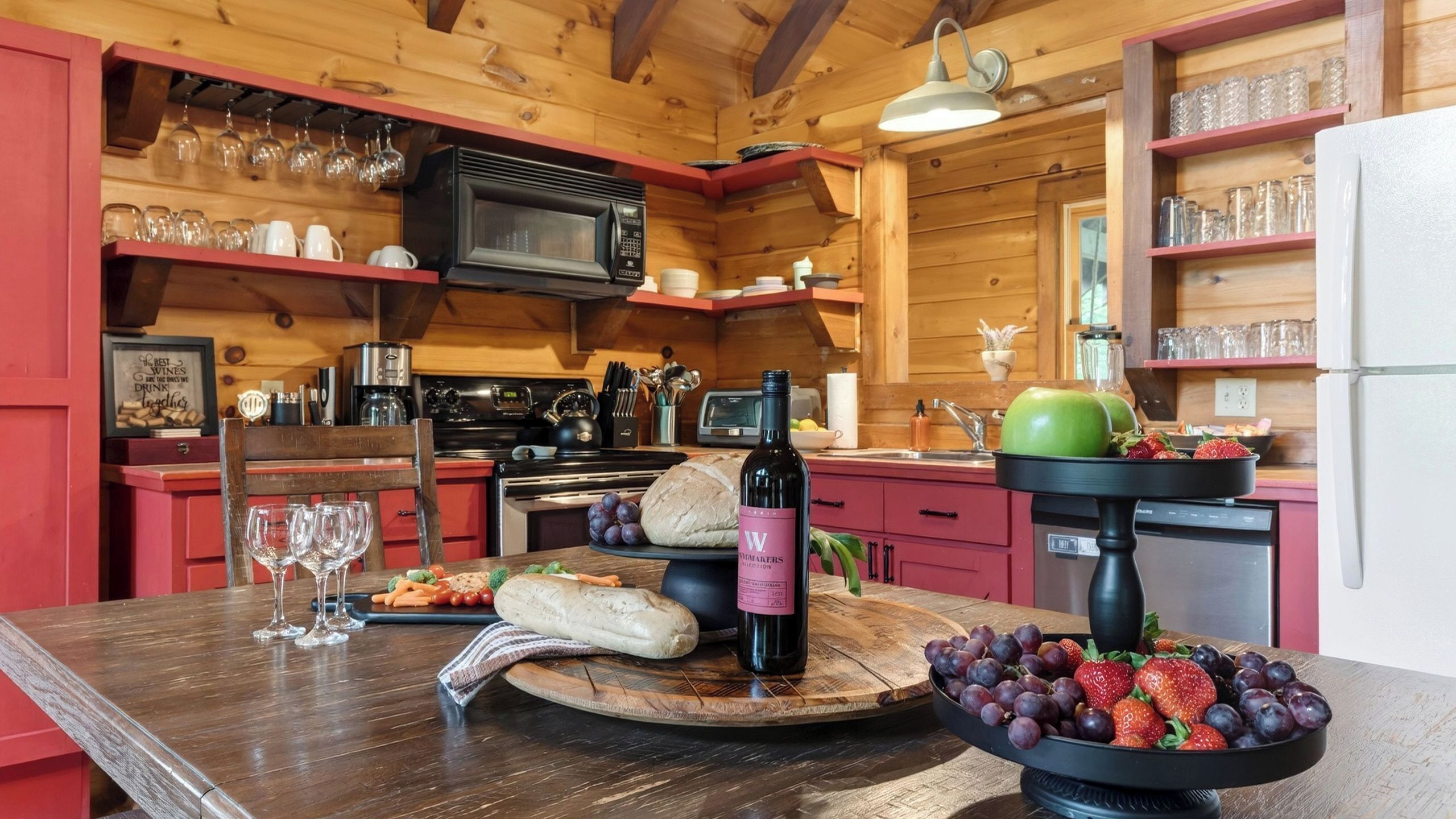 A wooden interior with a kitchen area featuring a microwave, oven, and various kitchen utensils.