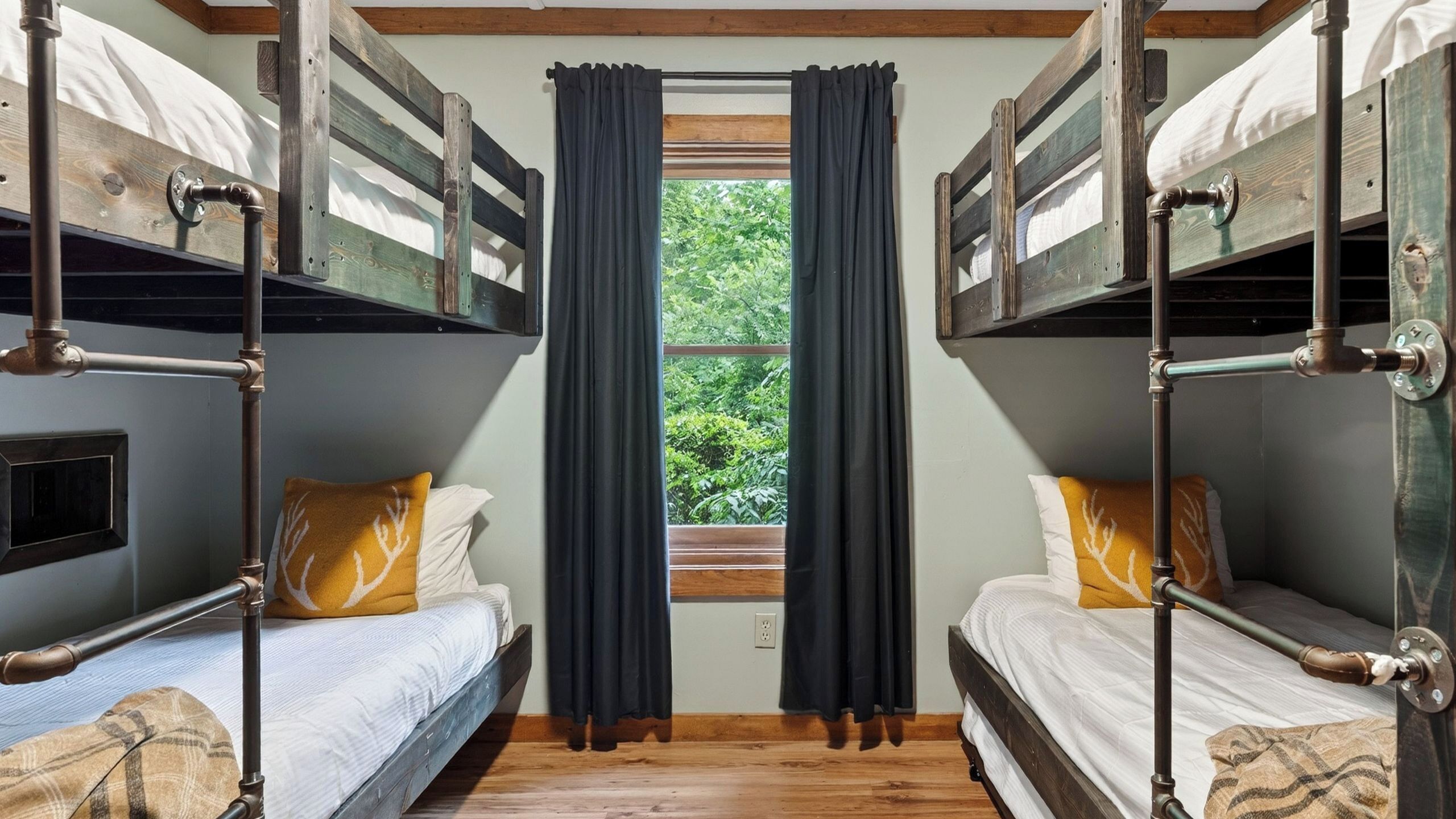 Una camera con un letto a castello, una finestra e tende.