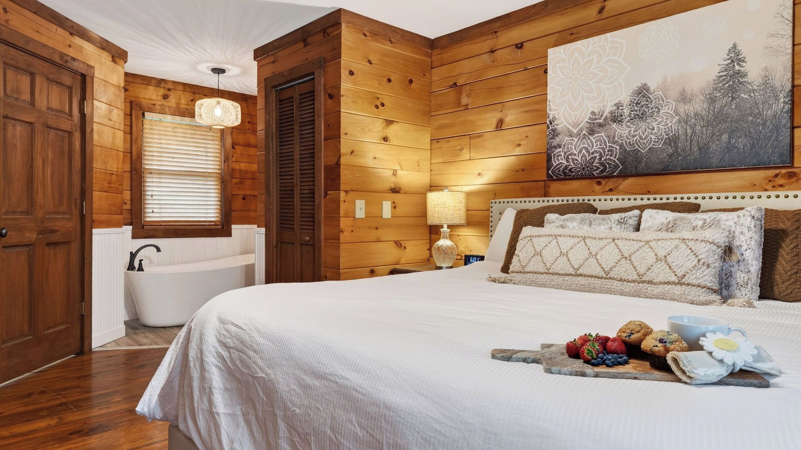 A wooden cabin-style bedroom with a large bed, a built-in bathtub, and a wall-mounted artwork.