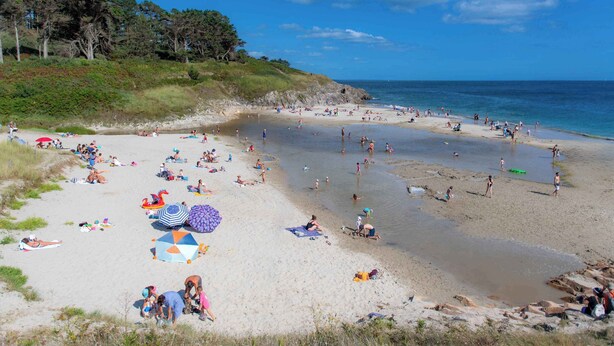 A beach with people sunbathing and swimming, umbrellas, and a clear sky. - Maison duplex avec wifi | Près de l'Aven (Pont-Aven)