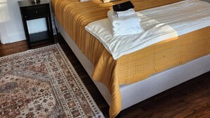 A neatly made bed with a headboard, two bedside tables with lamps, a patterned rug, and a framed picture on the wall. - Great House In Taylors Just Minutes To Downtown Greenville (Taylors)