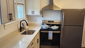 A modern kitchen with white cabinets, a stainless steel refrigerator, a stove, and a sink. - Great House In Taylors Just Minutes To Downtown Greenville (Taylors)
