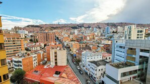 Uma área urbana densa, com diversos estilos arquitetônicos e uma avenida principal cortando o centro.