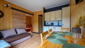 Un interior moderno con una mesa de comedor de madera, un sofá y una zona de cocina.