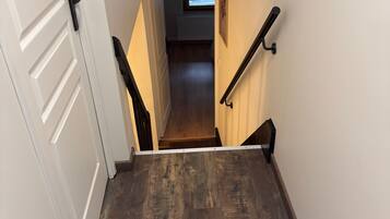 A narrow stairway with a dark wooden floor leading to a landing.