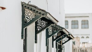 Eine Reihe von Fenstern mit aufwendigen schwarzen Metallrahmen und Zierarbeiten.