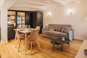 Ein modernes Wohnzimmer mit Essbereich, einer Couch und einem Couchtisch.