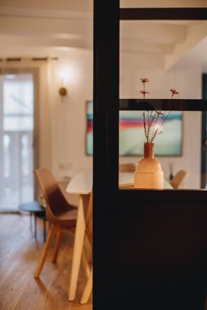Ein modernes Interieur mit einem Holzespeisetisch, Stühlen und einer Vase mit Ästen auf einem Tisch.
