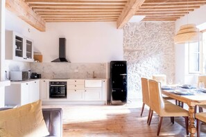 Eine moderne Küche mit weißen Schränken, einem eingebauten Backofen und einer schwarzen Dunstabzugshaube.