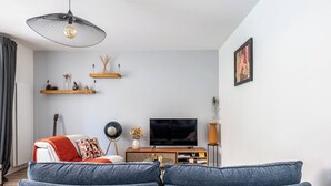 Un soggiorno con divano, televisore ed elementi decorativi su mensole.