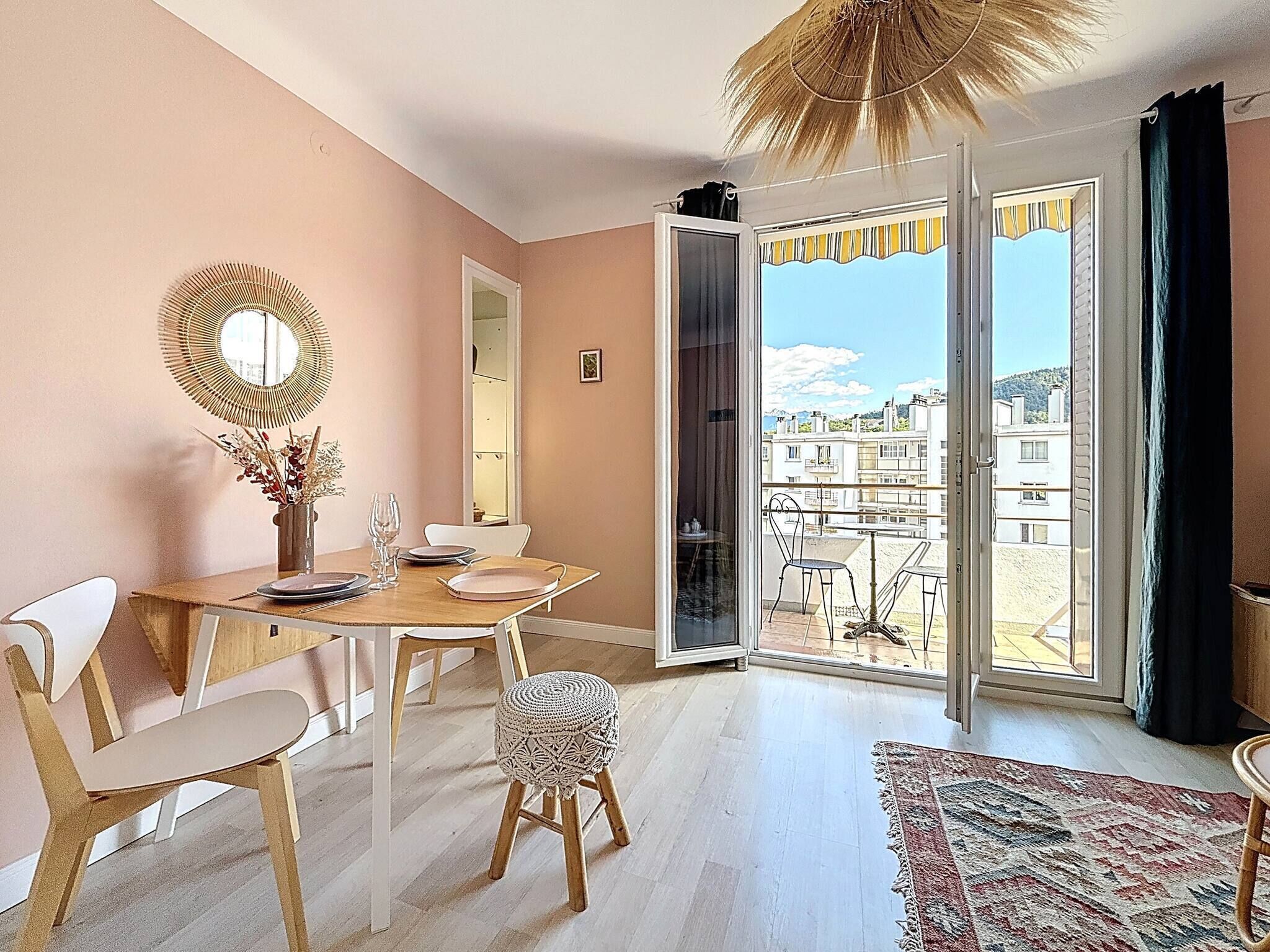 A dining area with a table, chairs, and a view through a glass door to an outdoor balcony.