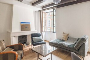 Ein Wohnzimmer mit Kamin, einer Couch, einem Couchtisch und einem Sessel.