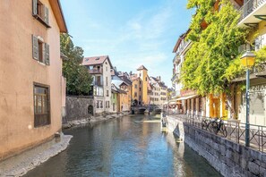 Ein schmaler Kanal, der von historischen Gebäuden mit Balkonen und einer Steinbrücke gesäumt wird.
