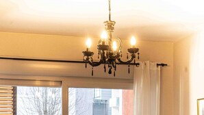 Una sala de estar con un sofá, una silla, una mesa de centro y una araña.