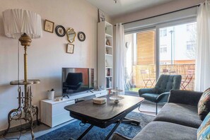 Ein Wohnzimmer mit Fernseher, Sofa und einem Tisch mit Dekorationen.