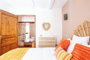 A bedroom with a bed, a dresser, a mirror, and a door leading to a bathroom. - Under the Annecy sky - Pedestrian street - City center - Balcony (Annecy)