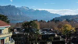 A residential area with modern buildings, a view of mountains, and a lake. - Studio Gatsby - Center Annecy - Balcony view lake (Annecy)