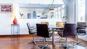 A modern dining area with a round table, black chairs, and pendant lighting. - At the gates of the old town - 2 bedrooms - Garage - Terrace (Annecy)