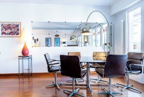 A modern dining area with a round table, black chairs, and pendant lighting. - At the gates of the old town - 2 bedrooms - Garage - Terrace (Annecy)