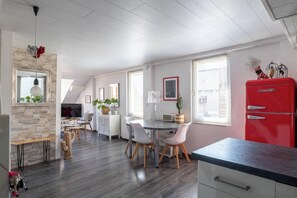 Eine moderne Küche mit Essbereich, einem roten Kühlschrank und einer Wand mit Steinverkleidung.