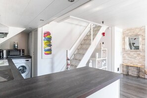 Eine moderne Küche mit Waschmaschine, Mikrowelle und einer Holzausziehtheke.