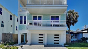 A two-story house with a balcony, a garage, and a wooden fence. - Ocean Escape (St. Augustine)
