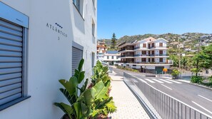 Ein Gebäude mit der Bezeichnung 'ATLÂNTICO 3' und Blick auf eine Wohngegend an einem Hang.