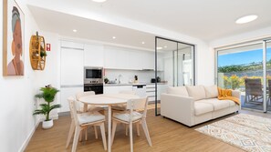 Eine moderne Wohnung mit Essbereich, Küche und einem Balkon mit Blick.