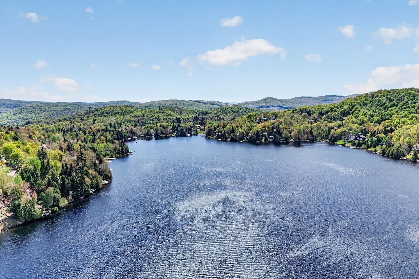 A lake surrounded by dense forest and hills.