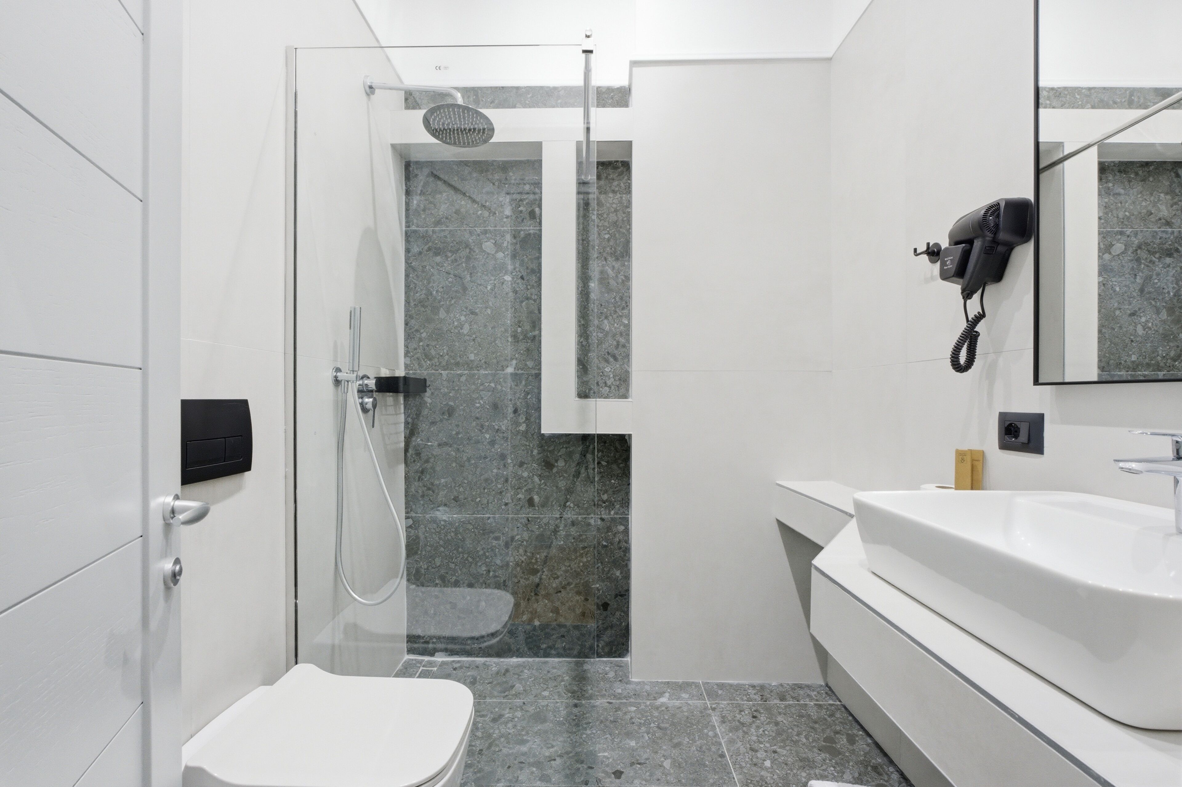 Une salle de bain moderne équipée d’une douche, de toilettes et d’un lavabo.