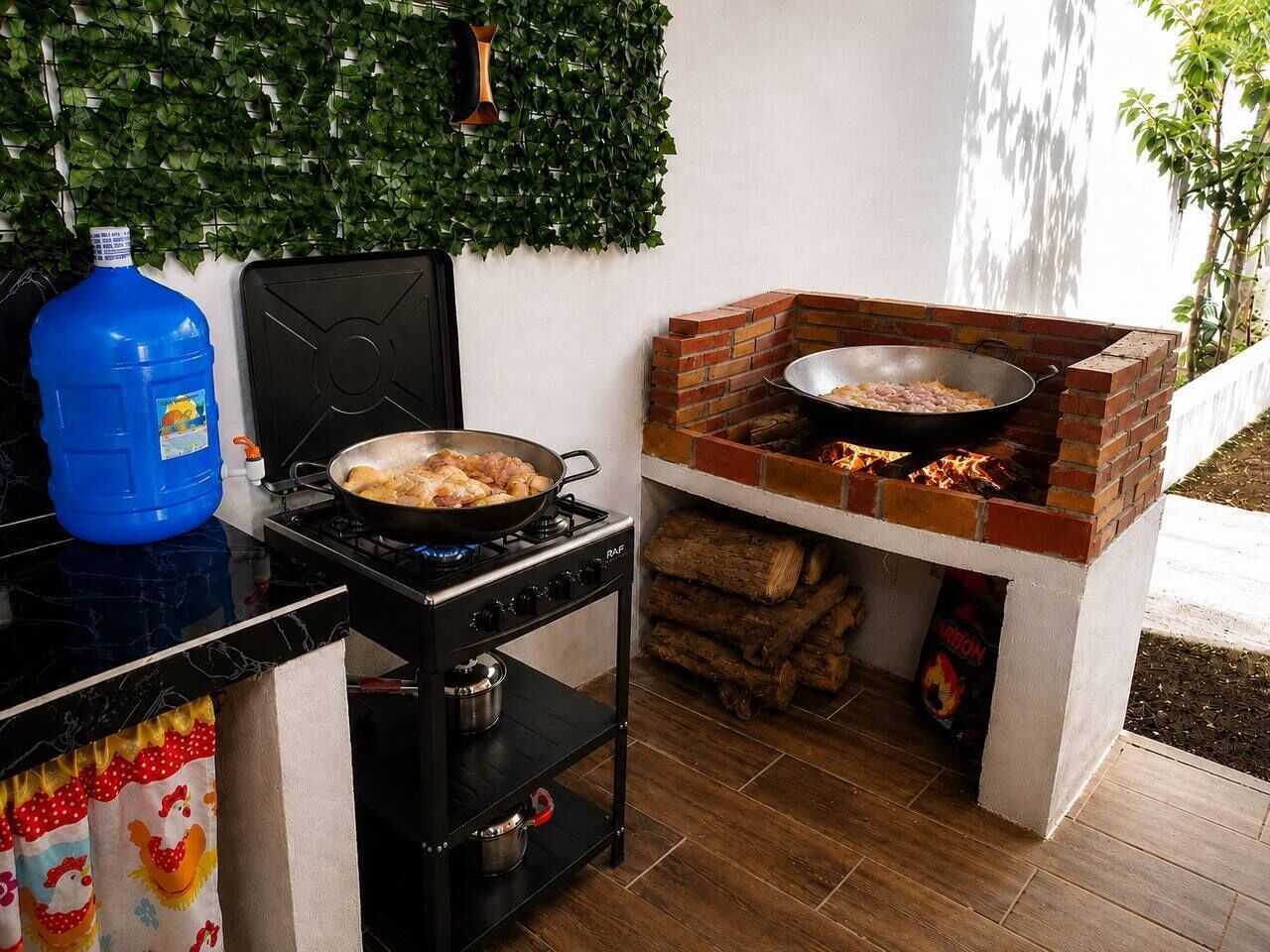 A kitchen with a gas stove, a brick oven, and a blue water jug.