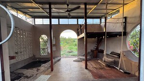 A spacious interior with a high ceiling, a central staircase, and a view of the outdoors. - Personal Retreat · Soaking Pool · Food Forest (Ometepe, Santa Cruz)