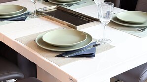 Mesa de jantar posta com pratos, copos e um menu.
