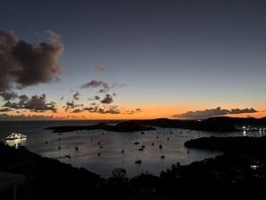 Un paysage côtier avec des bateaux au coucher du soleil.