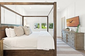 A four-poster bed with a wooden frame, a white bedspread, and multiple pillows. -  4 Bedroom- walk to private beach- Tennis-Pickleball- 2 Pools Sleeps 12 (Santa Rosa Beach)