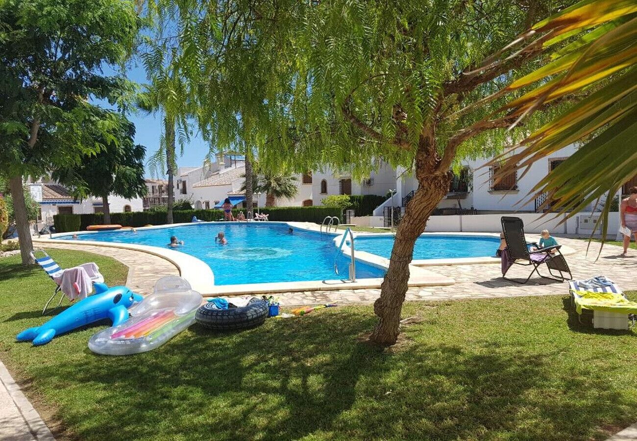Una piscina con sillas de descanso y juguetes inflables.