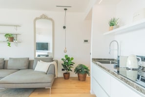 Una sala de estar moderna con un sofá, un espejo grande y plantas en macetas.