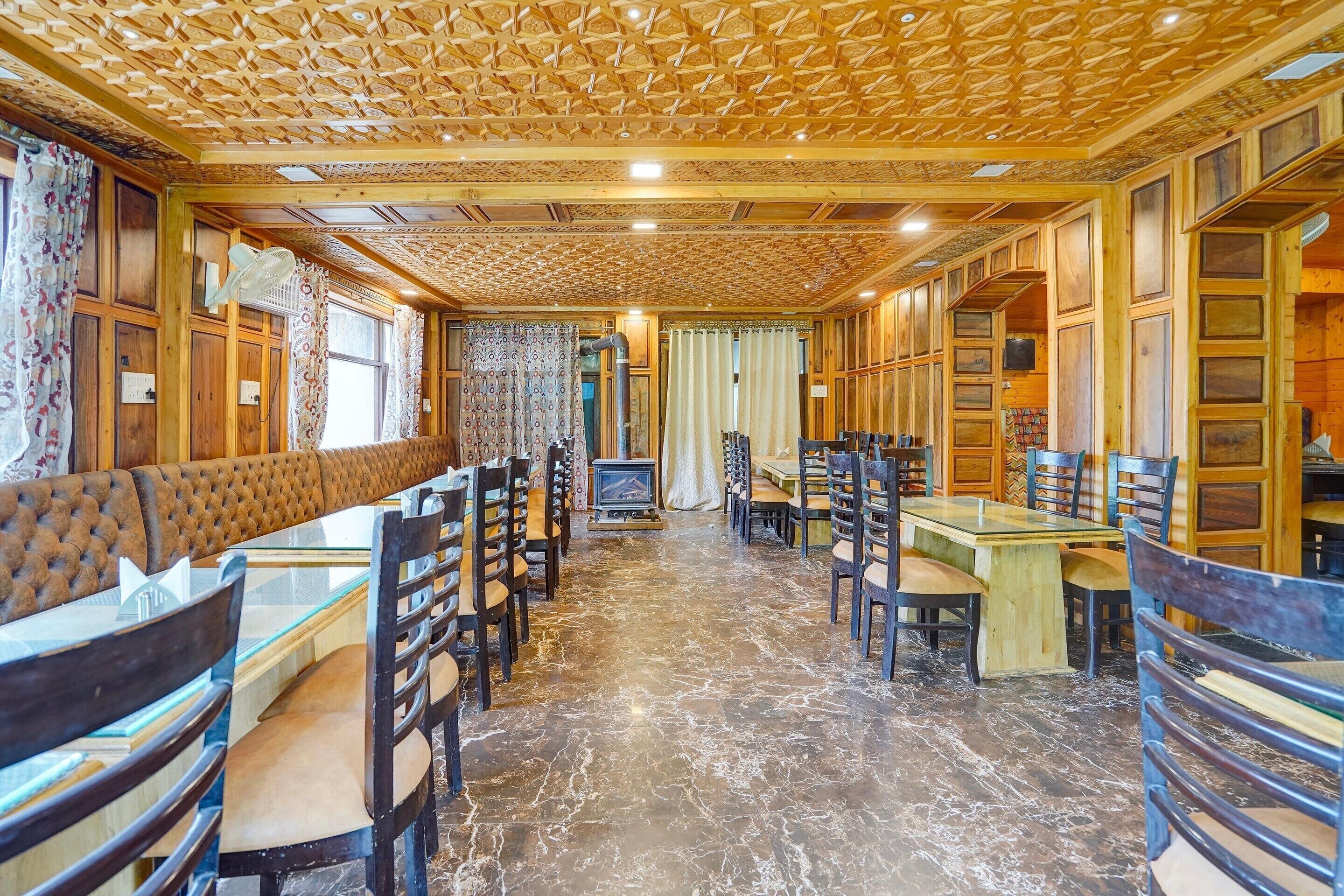 A cozy restaurant with wooden paneling, a fireplace, and a variety of seating options including booths and tables.