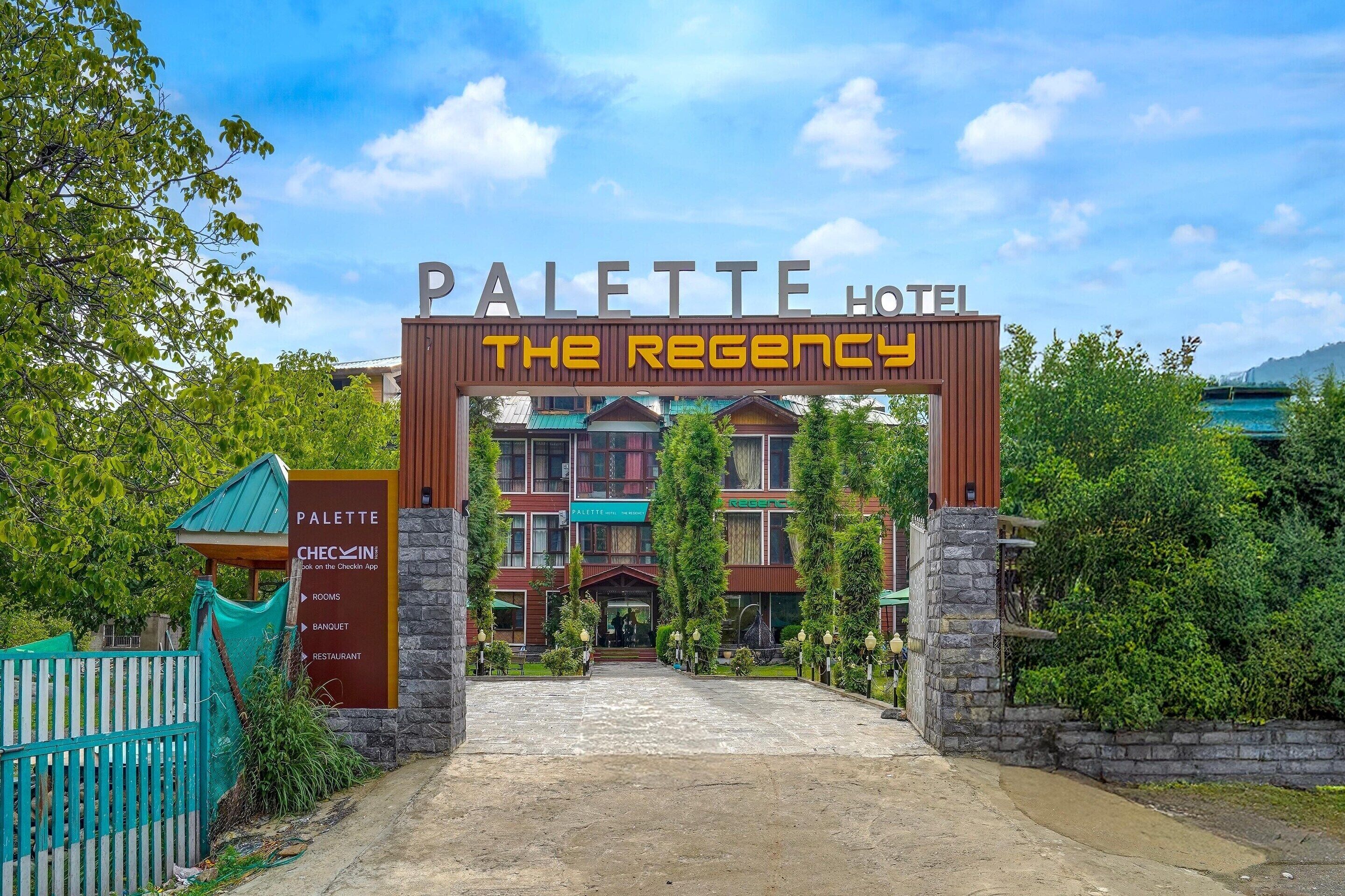 The entrance to the Palette Hotel, featuring a prominent archway with the hotel's name and a sign for the Regency.