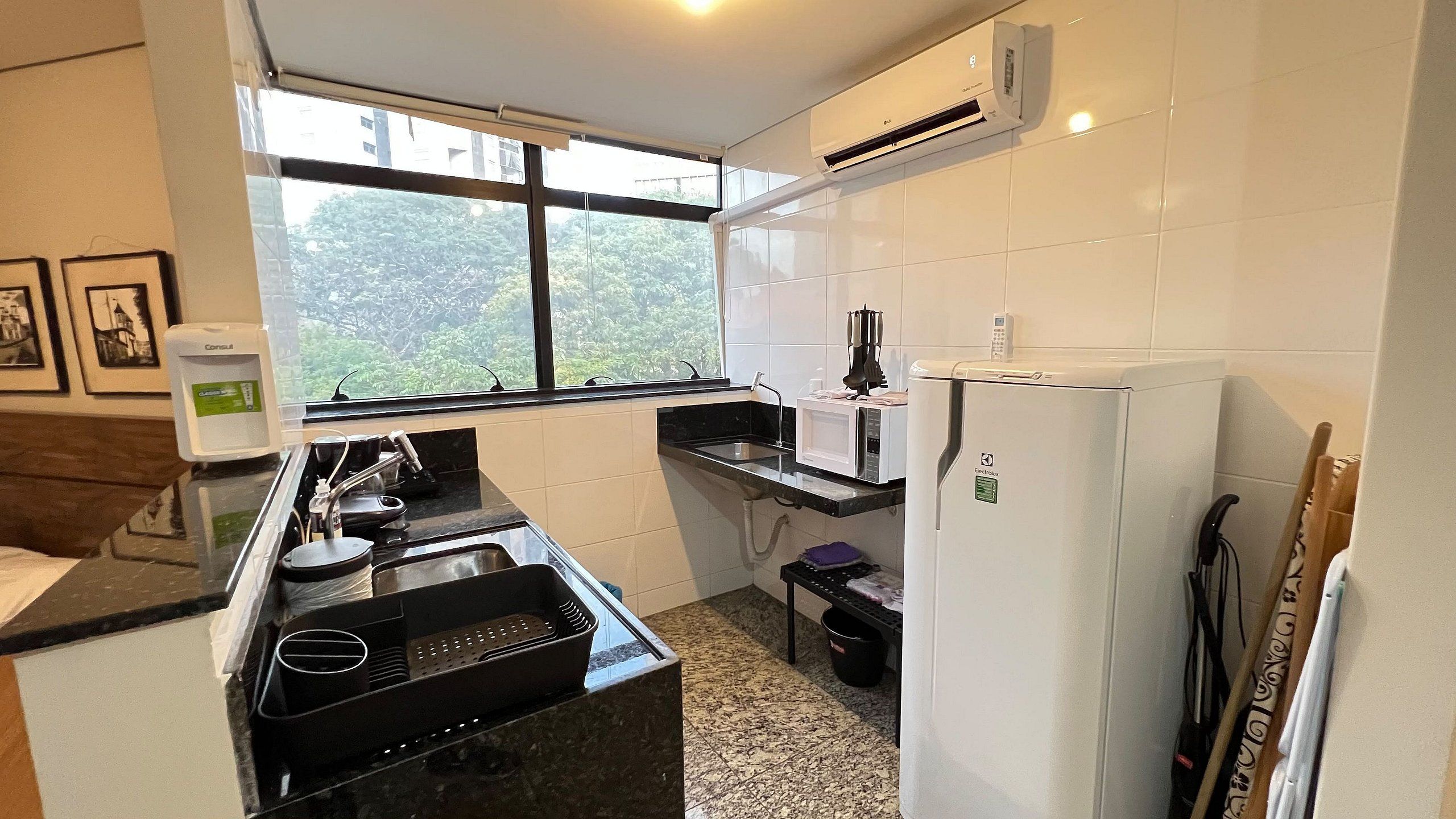 A compact kitchen with a gas stove, a microwave, and a refrigerator.