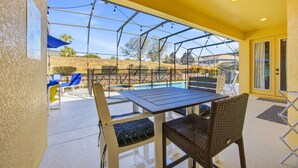 Une terrasse couverte avec une piscine, des sièges d’extérieur et une vue sur le paysage environnant.