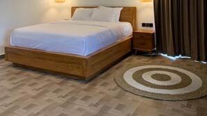 A bedroom with a wooden bed, a round rug, and three wall-mounted lights. - Cozzy Sagas  House Tabanan (Marga)
