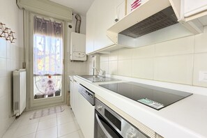 Uma cozinha moderna com forno embutido, lava-louças e bancada de aço inoxidável.