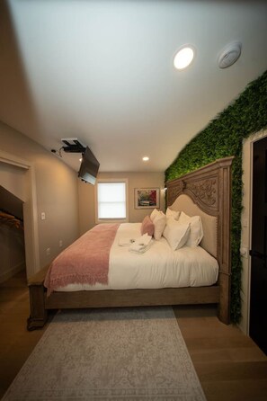 A bedroom with a bed, a window, a ceiling light, and a wall-mounted projector. - Boston Themed Luxury Stay w Hot tub and Jacuzzi (Medford)