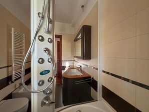 Un bagno con vasca, WC, lavandino e specchio.